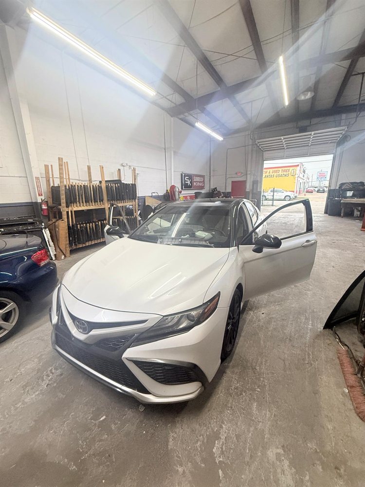 White Toyota Camry in for panoramic sunroof repair inside the Sunroof King shop in Houston