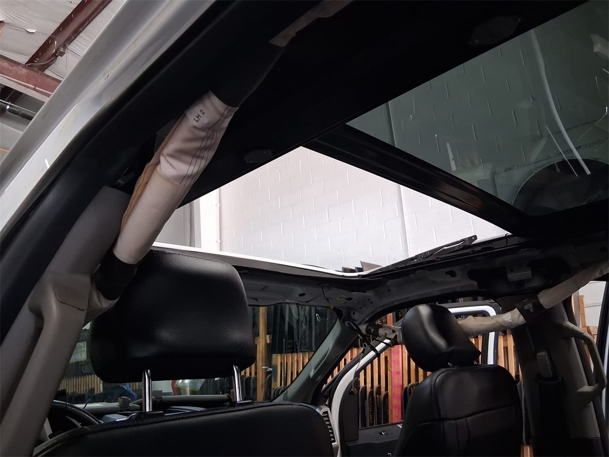 Ford roof opening with the sunroof assembly exposed during disassembly at the Sunroof King shop in Houston