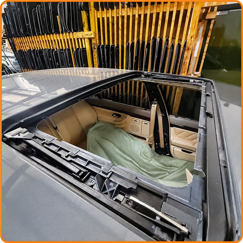 Open sunroof frame and mechanism exposed on a vehicle at Sunroof King