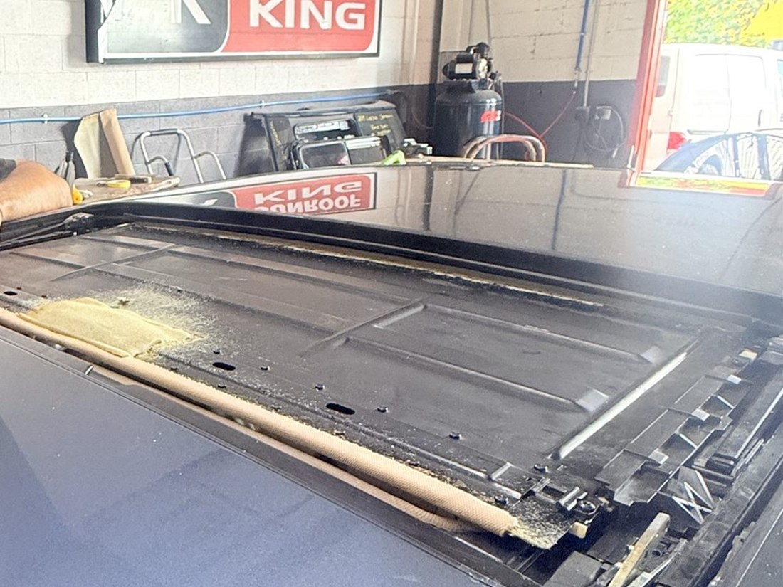 Sunroof opening with the glass panel removed, showing the frame and track at the Sunroof King shop in Houston