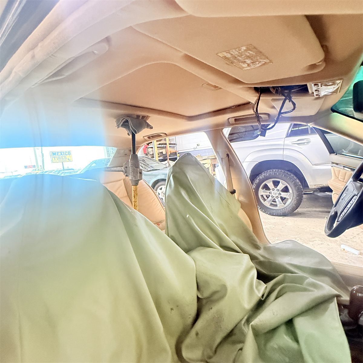 Vehicle interior with the seats covered for protection before headliner removal at Sunroof King in Houston