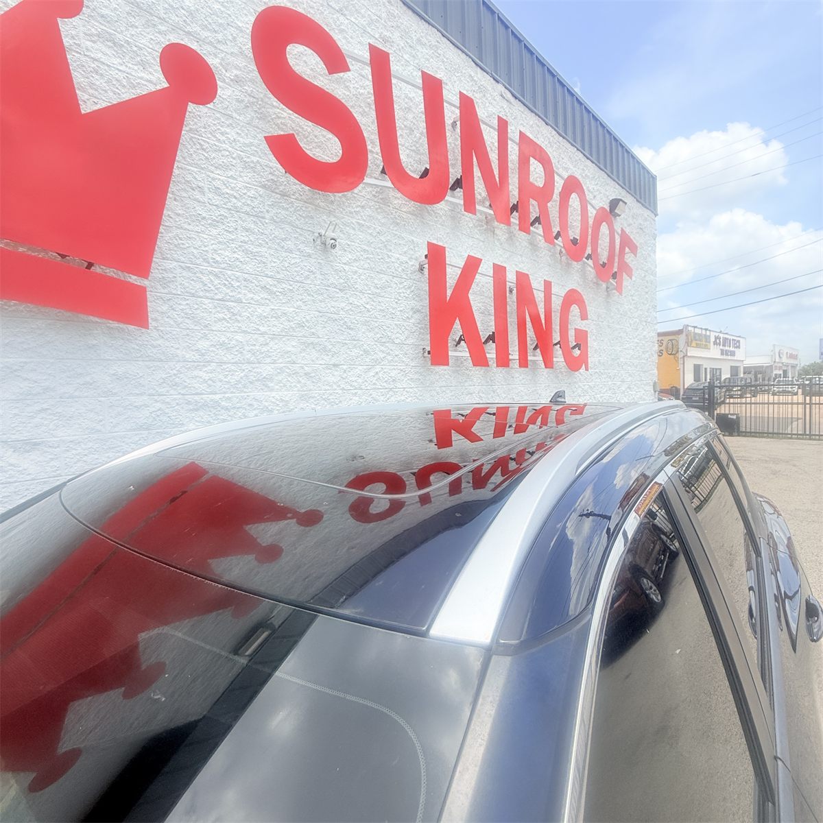 Vehicle with a panoramic glass roof parked at the Sunroof King building on Westpark Dr in Houston