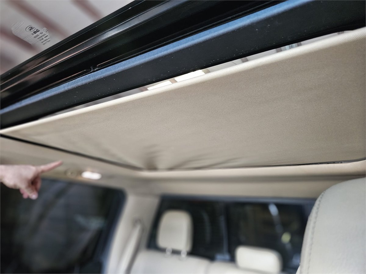 Close-up of a panoramic sunroof shade that has come away from its edge and dropped out of position, inspected at Sunroof King in Houston