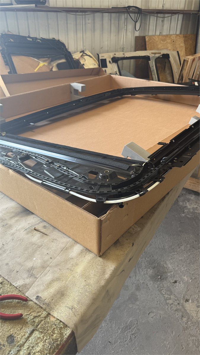 Sunroof cassette frame on the workbench at the Sunroof King shop in Houston during a shade repair