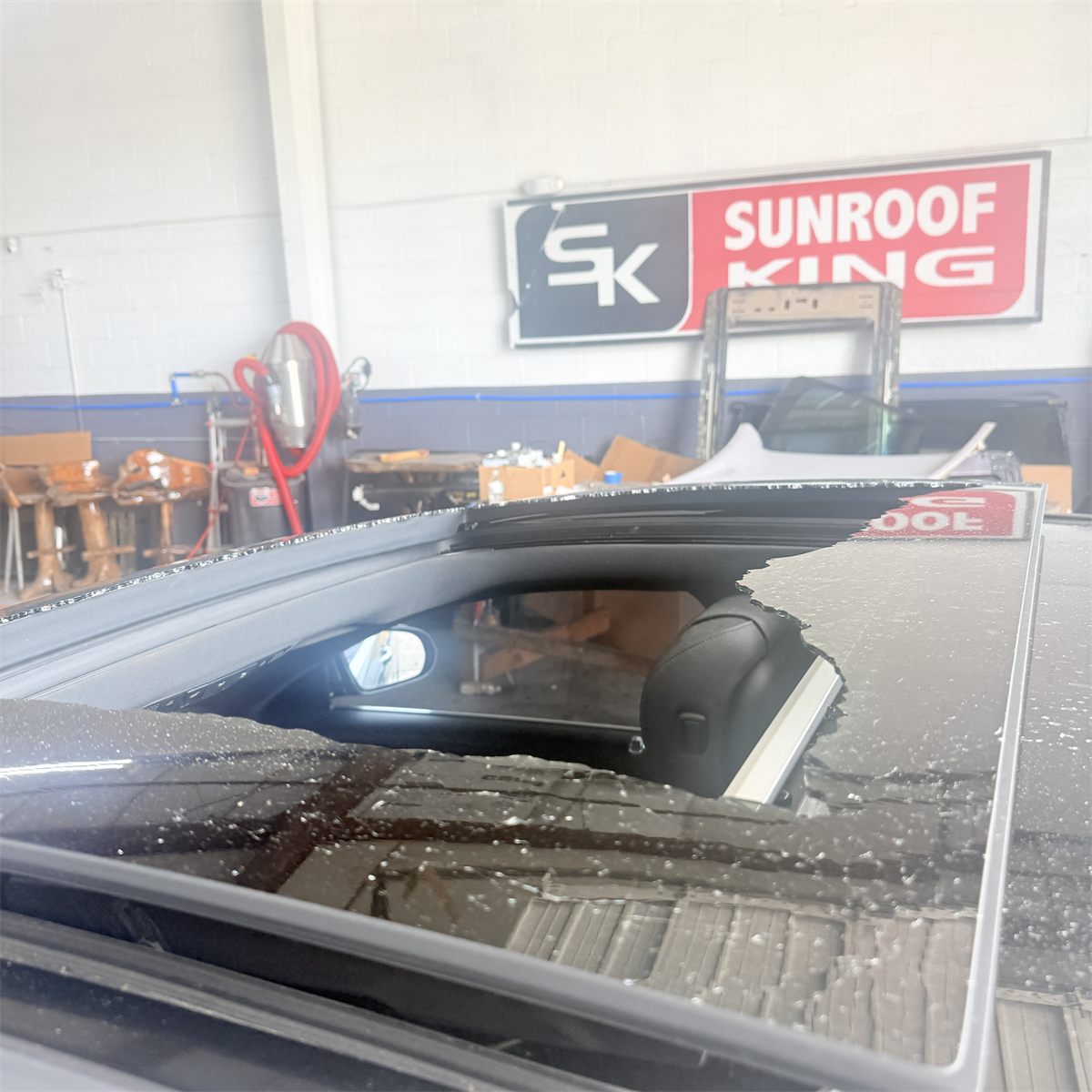Broken sunroof glass on a vehicle brought into the Sunroof King shop in Houston for replacement