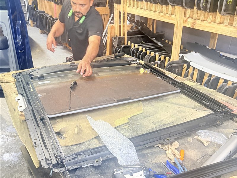 Sunroof King technician servicing a sunroof cassette and drain tray