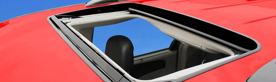 Inbuilt sliding sunroof panel retracted into the roof of a red vehicle