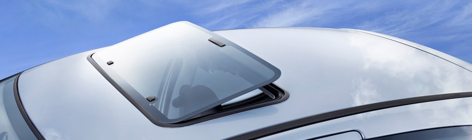 Pop-up sunroof panel hinged open at the rear of a vehicle roof
